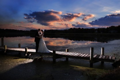 18-married-couple-kissing-on-dock-at-sunset